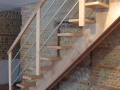 Escalier sur double crémaillère centrale en hêtre vernis incolore avec lisses en aluminium